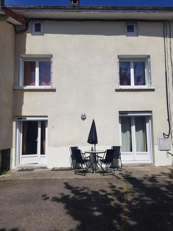 ein Tisch und Stühle vor einem Gebäude in der Unterkunft Maison de l'harmonie à Limoges in Limoges
