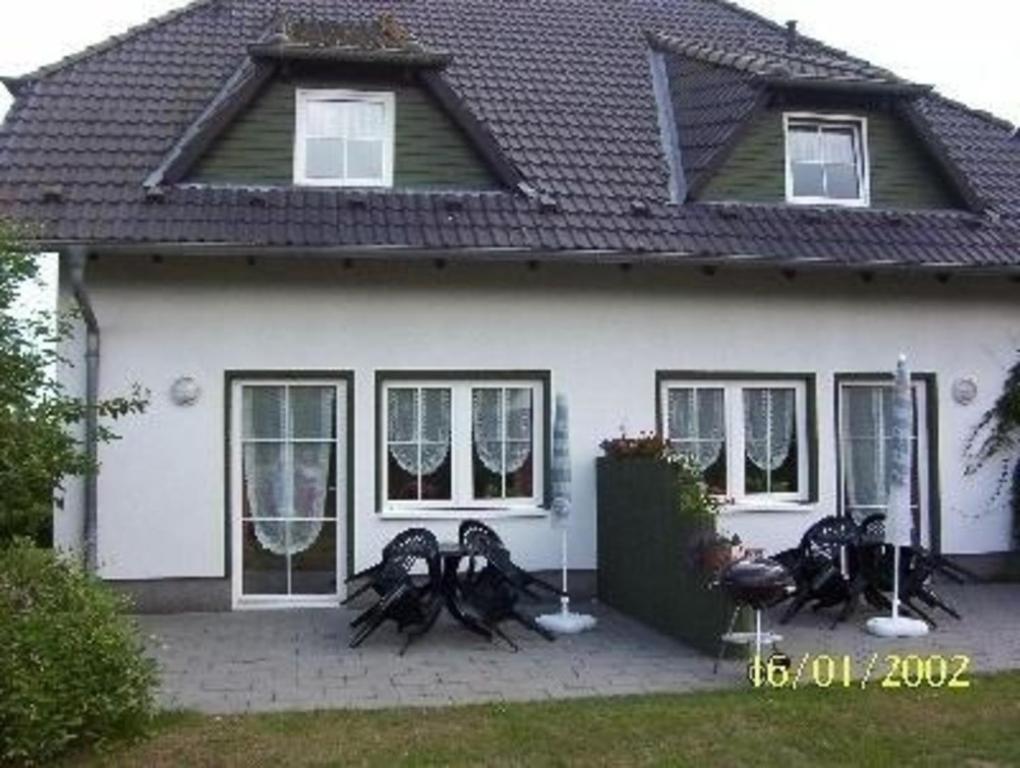 une maison blanche avec des chaises devant elle dans l'établissement Ferienwohnung für 2 Personen ca 32 qm in Pantow, Ostseeküste Deutschland Rügen, à Pantow