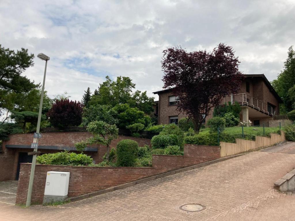 ein Haus mit einer Backsteinmauer neben einer Straße in der Unterkunft Ferienwohnung am Panoramaweg 