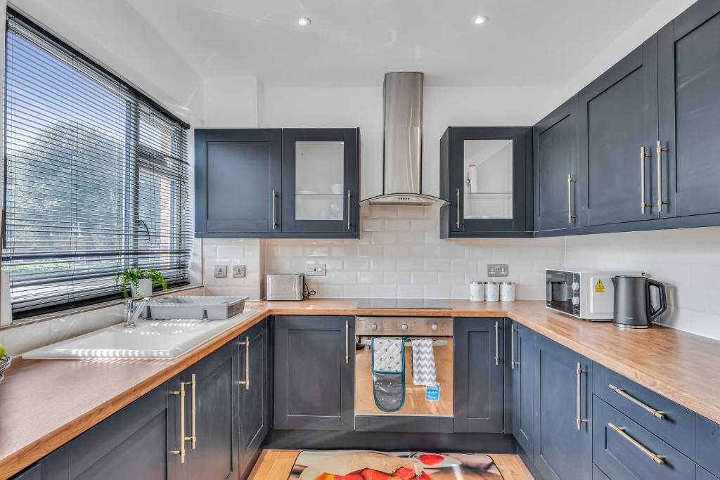 a kitchen with blue cabinets and a sink at Relaxed Home in Eltham