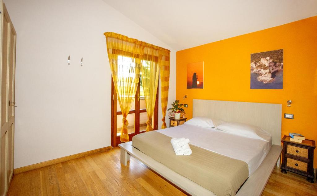 1 dormitorio con paredes amarillas y 1 cama grande en Agriturismo La Sassicaia, en Castiglione della Pescaia