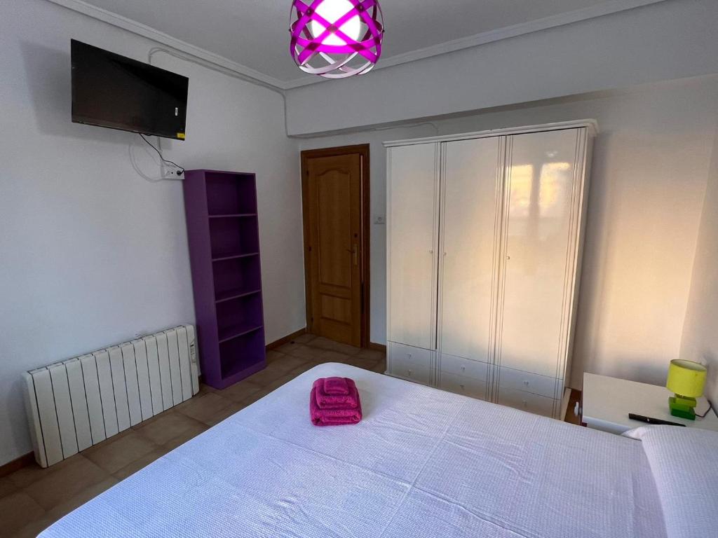 sypialnia z dużym łóżkiem z różową torbą w obiekcie Apartamento en el Parque w mieście Ontinyent