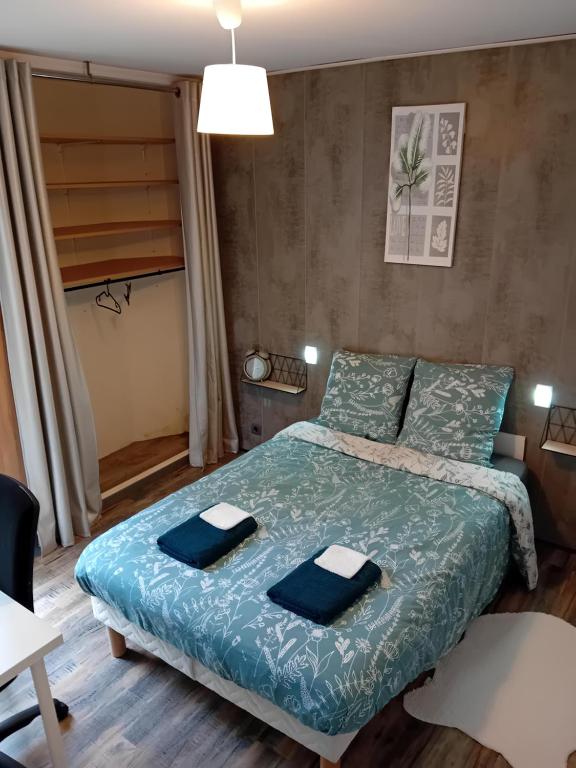 a bedroom with a bed with two towels on it at Appartement - Élancourt, France Avec WIFI in Élancourt