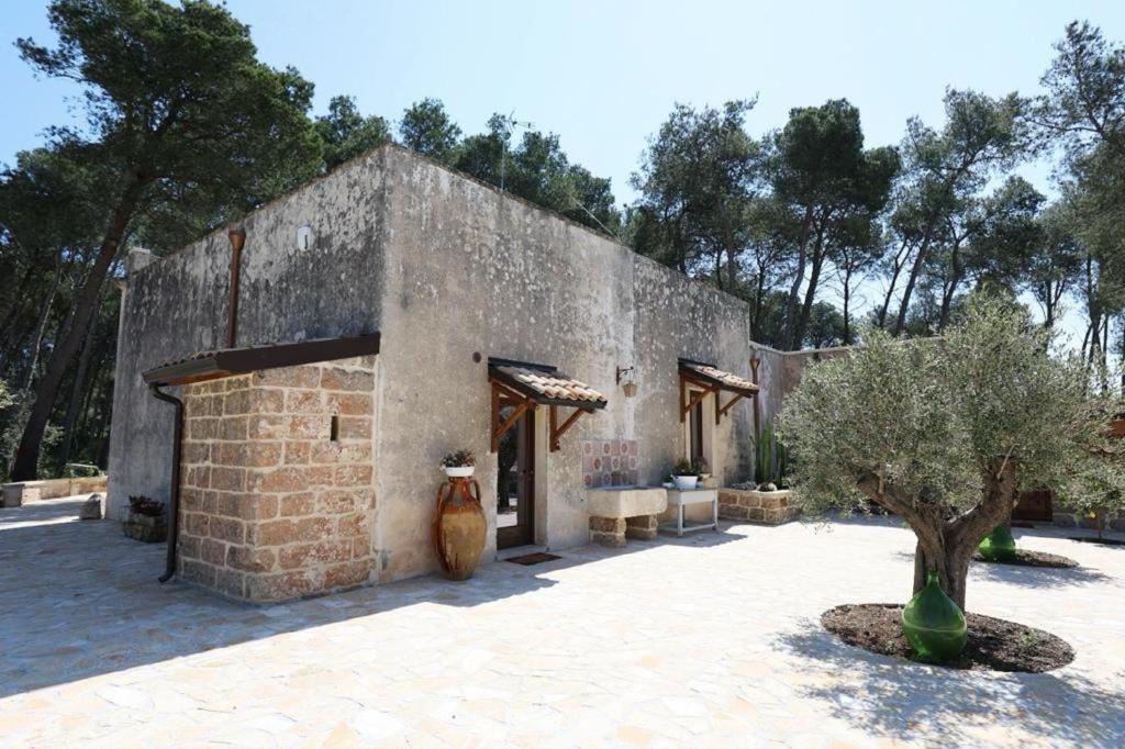 un edificio in pietra con un vaso davanti di villa dei cento Pini a Monteroni di Lecce