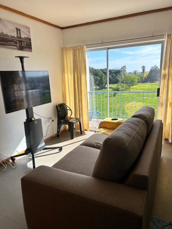 a living room with a couch and a large window at Fine living apartment in Vredendal