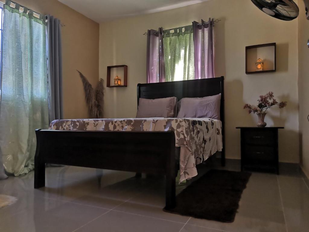 ein Schlafzimmer mit einem Bett in einem Zimmer mit Fenstern in der Unterkunft Areito Vintage in Enriquillo