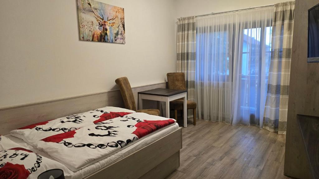 a bedroom with a bed and a chair and a window at Apartment im Hotel Rottalblick in Oberham