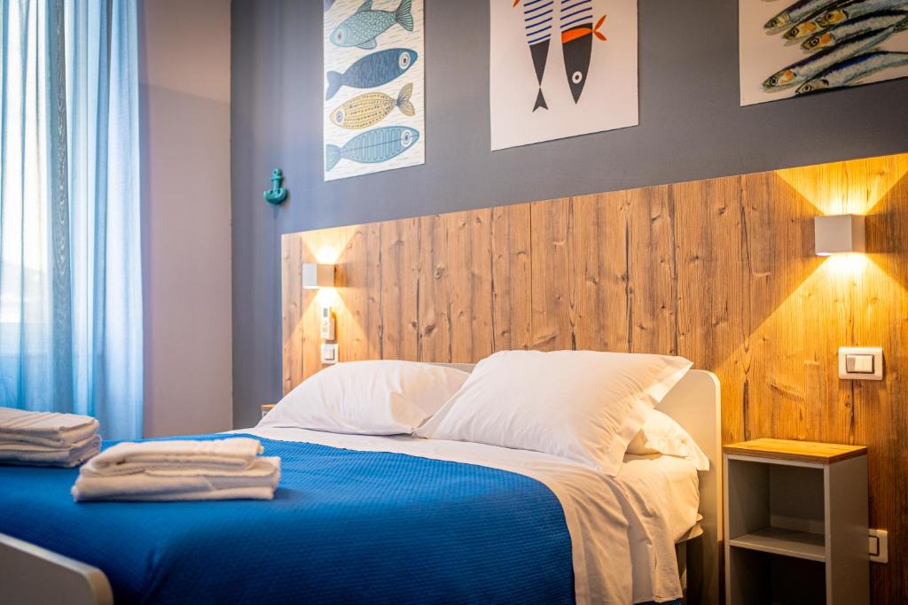 een slaapkamer met een blauw bed en een houten hoofdeinde bij i sapori del levante in La Spezia