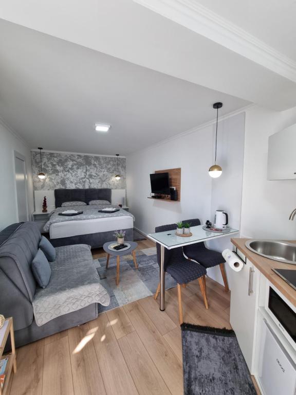 un soggiorno con letto e tavolo in una camera di Apartments Deni a Mostar