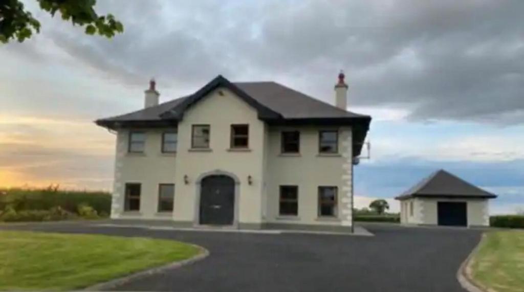 a large white house with a driveway at Country Hideaway in Limerick