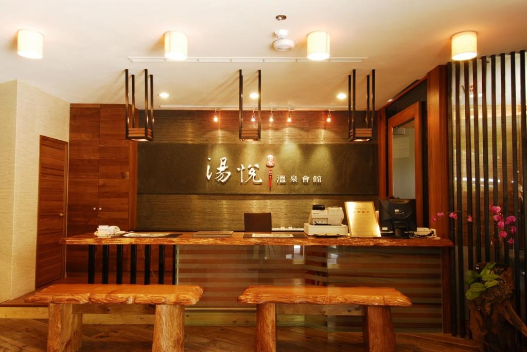 a restaurant with a counter with two benches in a room at Tangyue Resort in Tai&#39;an