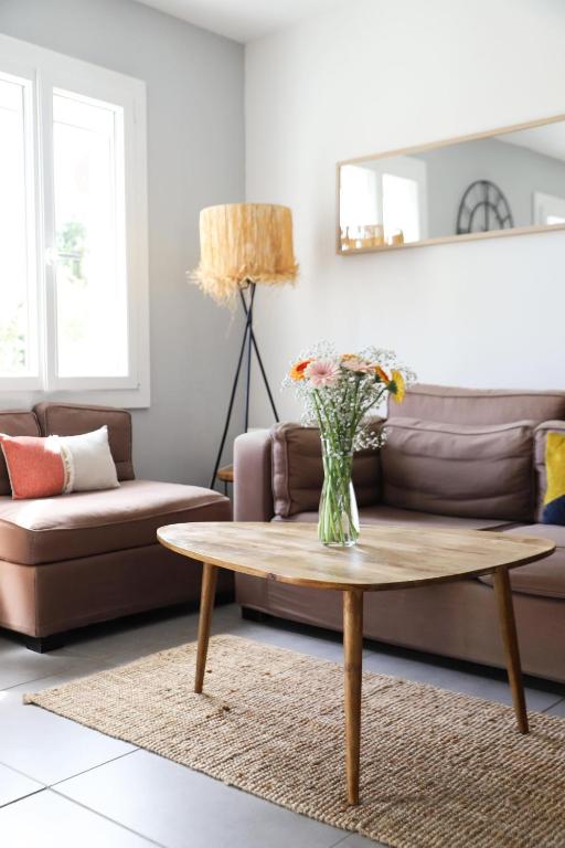 een woonkamer met een vaas met bloemen op een salontafel bij Maison - 3 chambres - Jardin in Huisseau-sur-Cosson