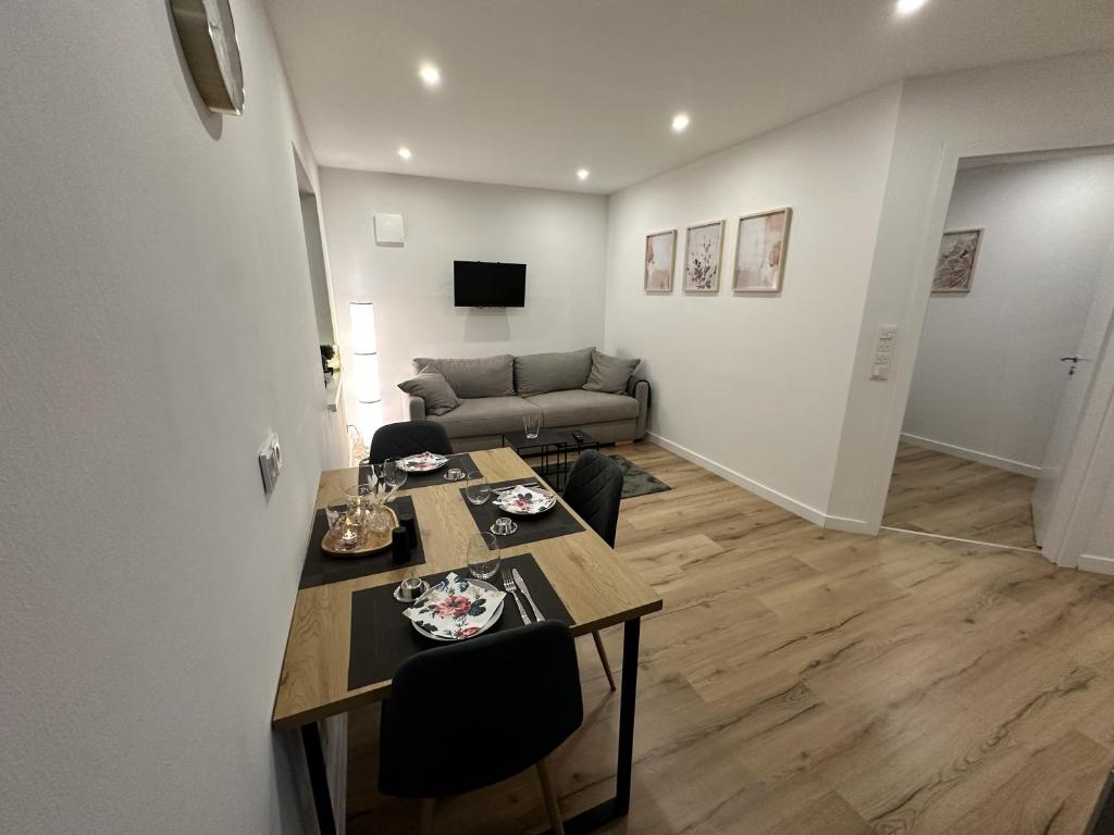a living room with a table and a couch at Fewo am Tillysee in Wardenburg in Wardenburg