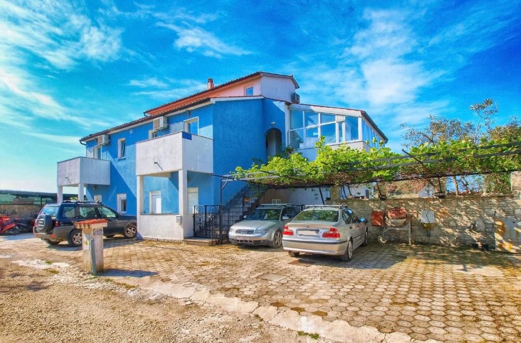 een blauw huis met auto's ervoor geparkeerd bij Ferienwohnung für 2 Personen ca 24 qm in Fažana, Istrien Istrische Riviera - b60963 in Fažana