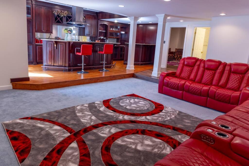 a living room with a red couch and a kitchen at Luxurious Private Basement Suite in Ashton in Silver Spring