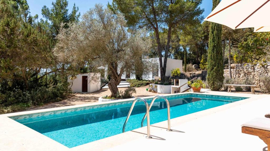 a swimming pool in a villa with a garden at SURF HOUSE in Sant Josep de sa Talaia
