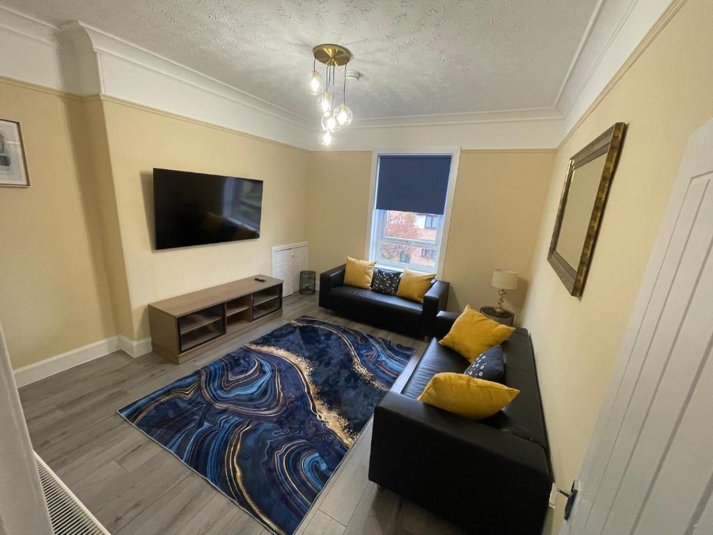 a living room with a couch and a flat screen tv at Gateway to the Loch in Balloch