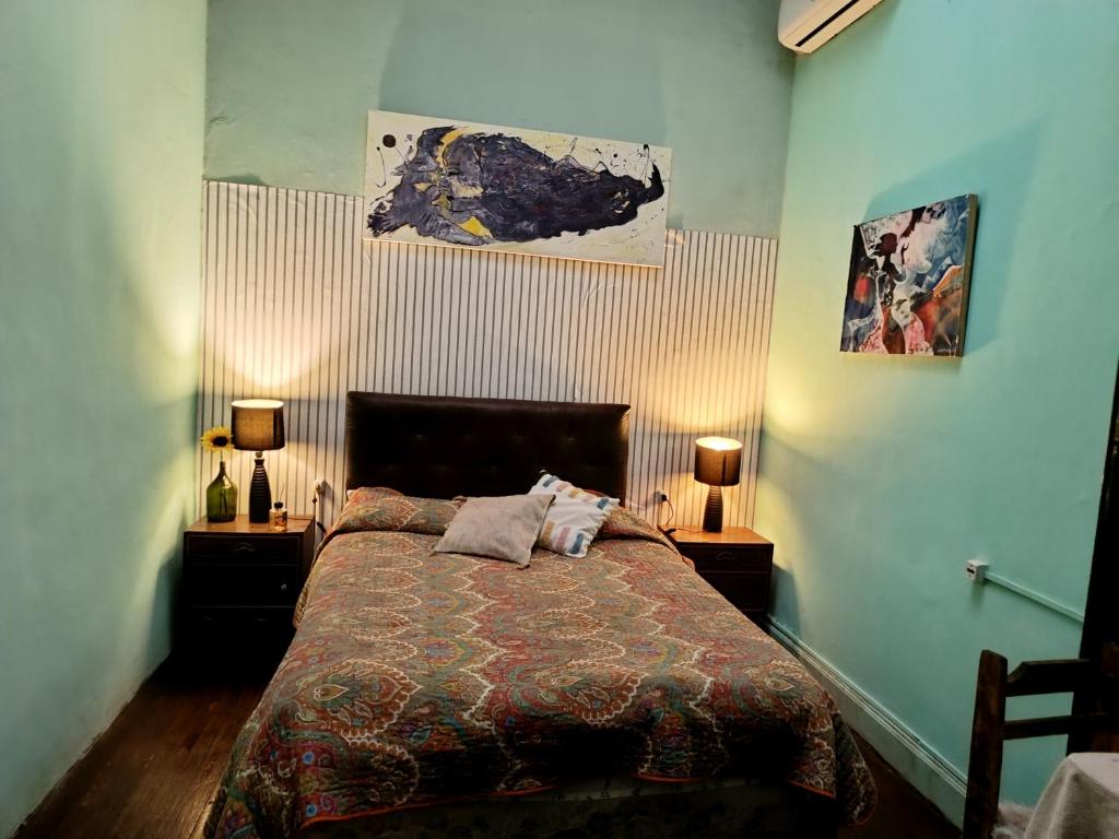 a bedroom with a bed with two night stands and two lamps at El secreto Casa Art in Montevideo