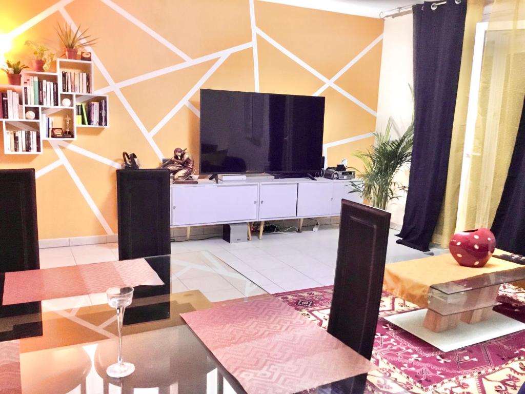 un salon avec une télévision à écran plat sur un mur dans l'établissement APPARTEMENT T2 VELODROME PRADO, à Marseille