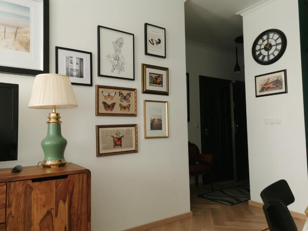 ein Wohnzimmer mit einer Wand mit gerahmten Bildern in der Unterkunft Green&Wood in Puck