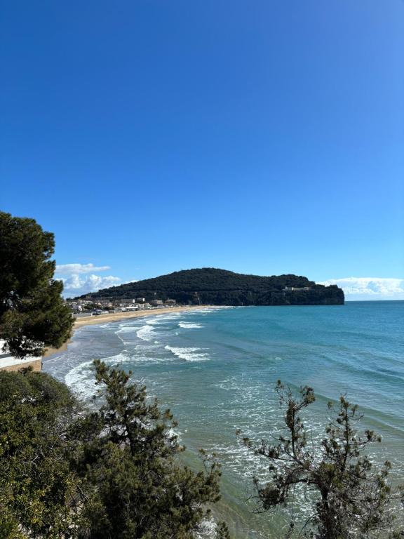 a view of a beach with trees in the foreground at Il Palazzetto in Gaeta