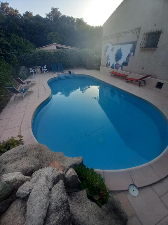une grande piscine bleue à côté d'une maison dans l'établissement studio 1 pièce 16 m2 climatisé 2 personnes piscine partagée, à Porto-Vecchio