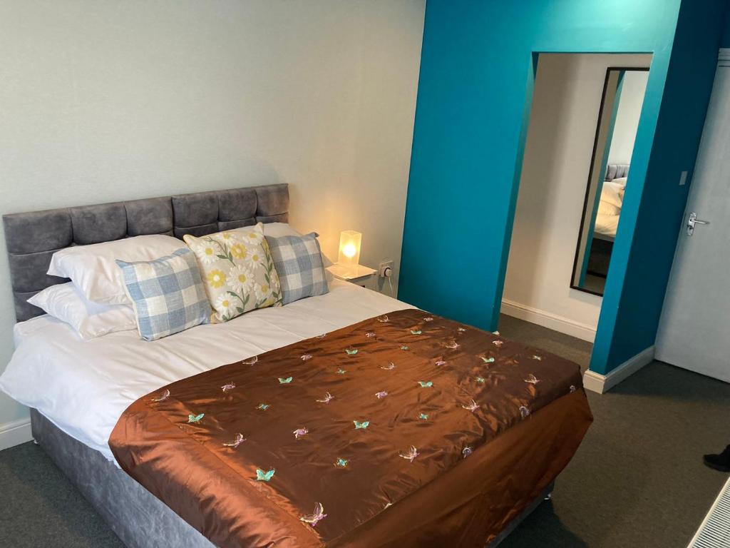 une chambre avec un grand lit avec une couverture marron dans l'établissement Selwyn Stays, à Liverpool