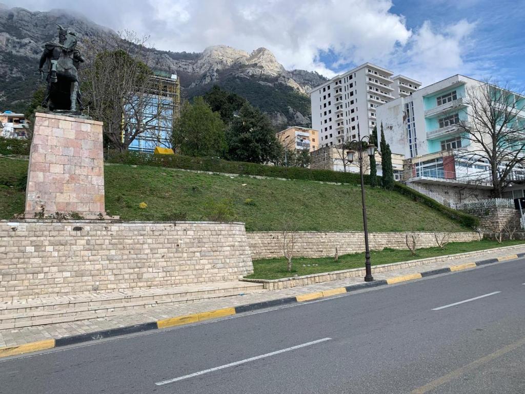 una estatua al lado de una calle con una montaña en Kruja Shared Apartment, en Krujë