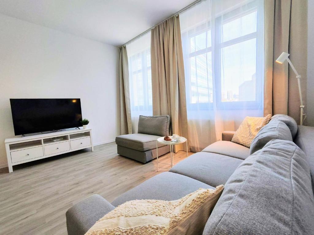 a living room with a couch and a flat screen tv at Cinnamon - free private parking - old town - air conditioning in Bratislava