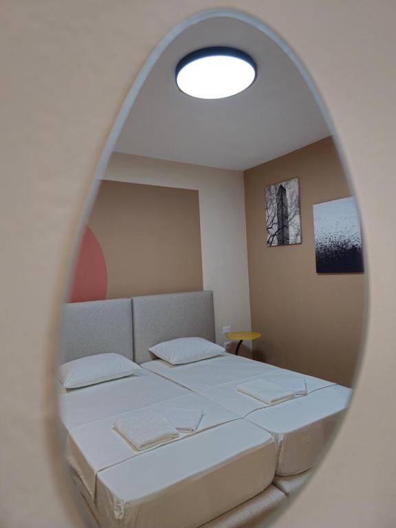 a bedroom with a bed and a round mirror at Center Cozy Nest in Tirana