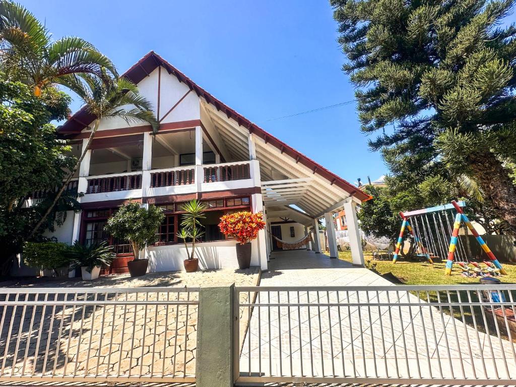 ein Haus mit einem Spielplatz davor in der Unterkunft Casa na Praia dos Ingleses para até 12 pessoas in Florianópolis