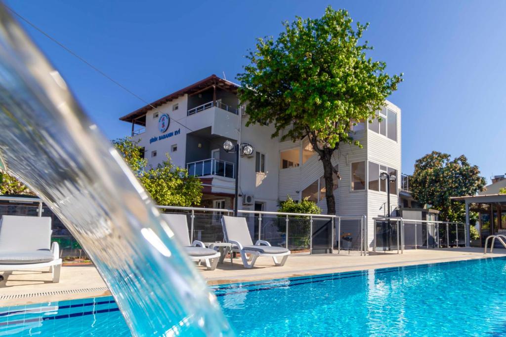 a pool with a water fountain in front of a building at Şirin Baba Otel in Fethiye