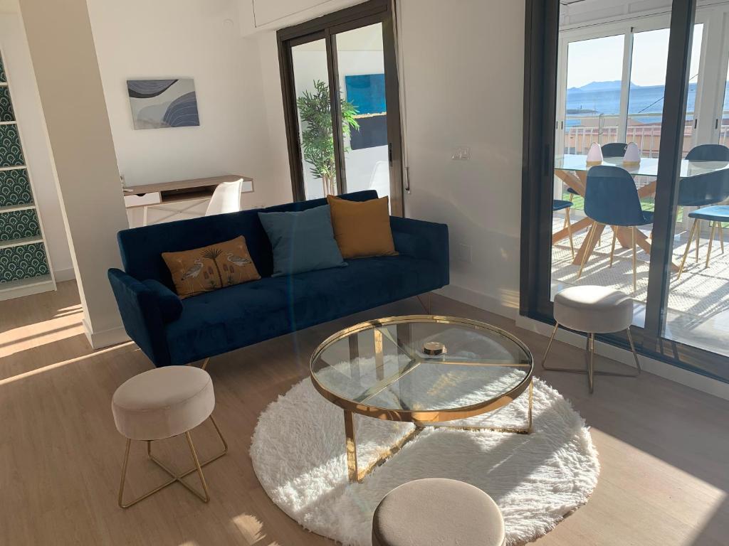 a living room with a blue couch and a glass table at ARENA & MAR in El Campello
