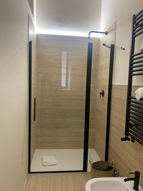 a glass shower in a bathroom with a sink at Veneto Serviced Apartment by SupaStays in Rome