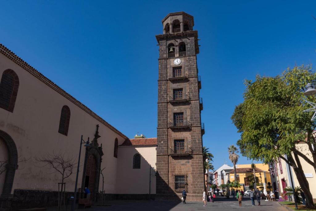 a tall clock tower in front of a building at Apartamentos la Concepción grupos in Las Lagunas