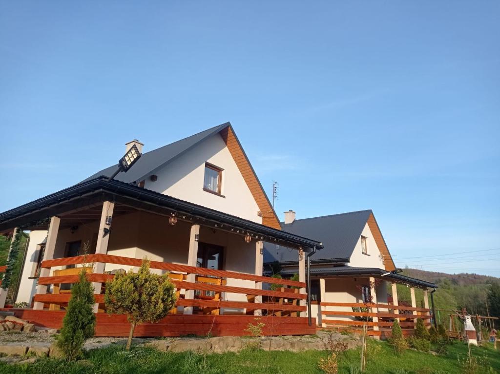 a house with a black roof at Domki w Bieszczadzkiej Dolinie in Ustrzyki Dolne