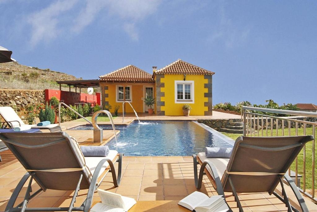 a house with a pool and two chairs in front of it at Ferienhaus mit Privatpool für 7 Personen ca 130 qm in Tijarafe, La Palma Westküste von La Palma in Tijarafe