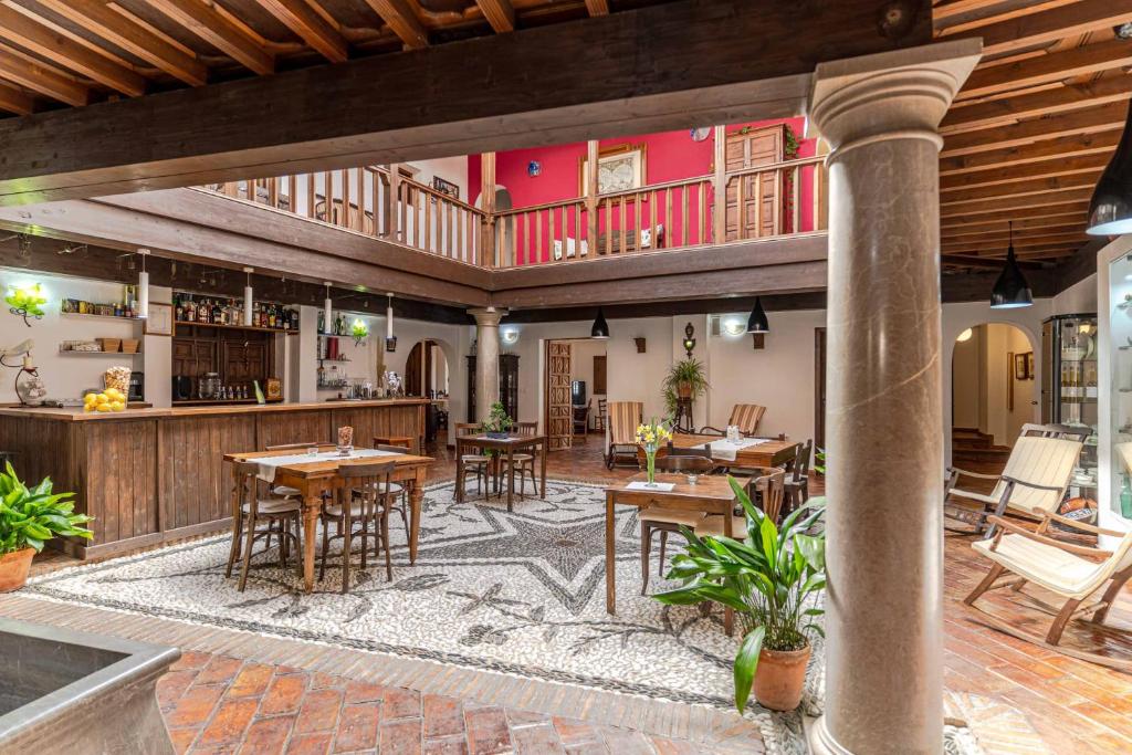un patio al aire libre con mesas y un bar en El Secreto del Olivo, en Nigüelas