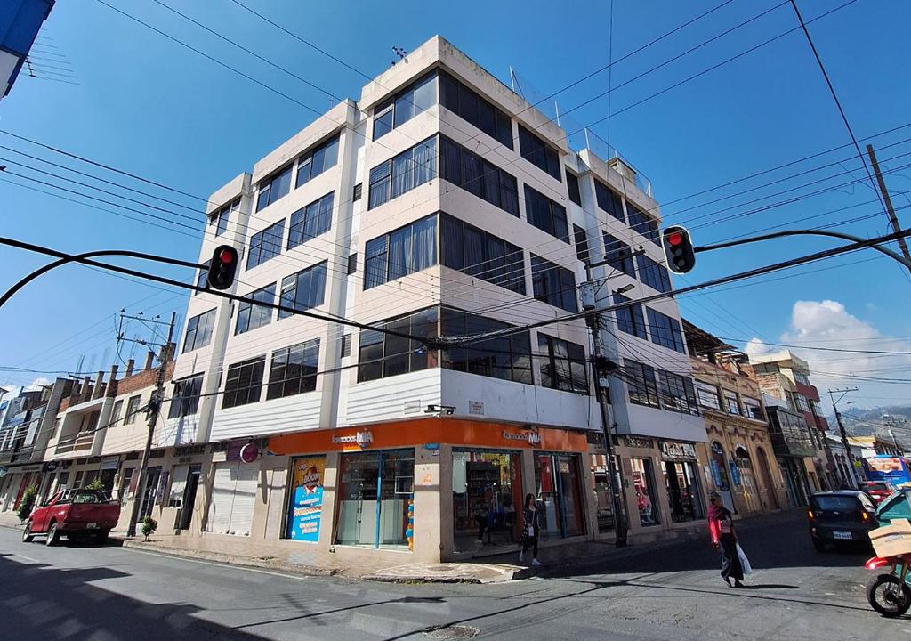 een gebouw op een straathoek met een verkeerslicht bij La Merced Plaza Hospedaje in Riobamba