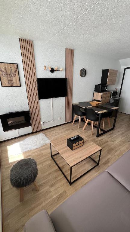 een woonkamer met een tafel en een bank bij Studio la Mongie Tourmalet 2 étoiles in Bagnères-de-Bigorre