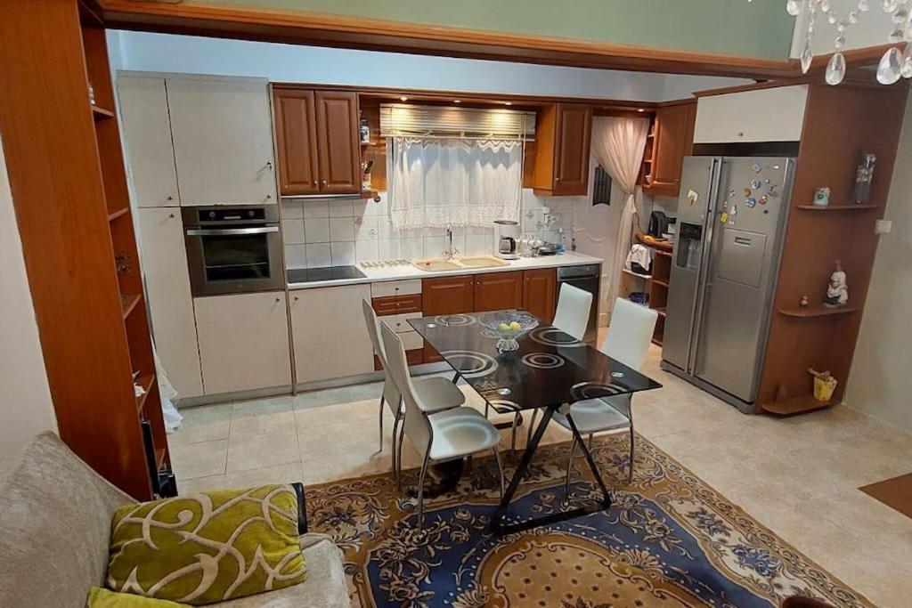 Apartment in quiet neighbourhood in Alimos في أثينا: مطبخ مع طاولة وغرفة طعام