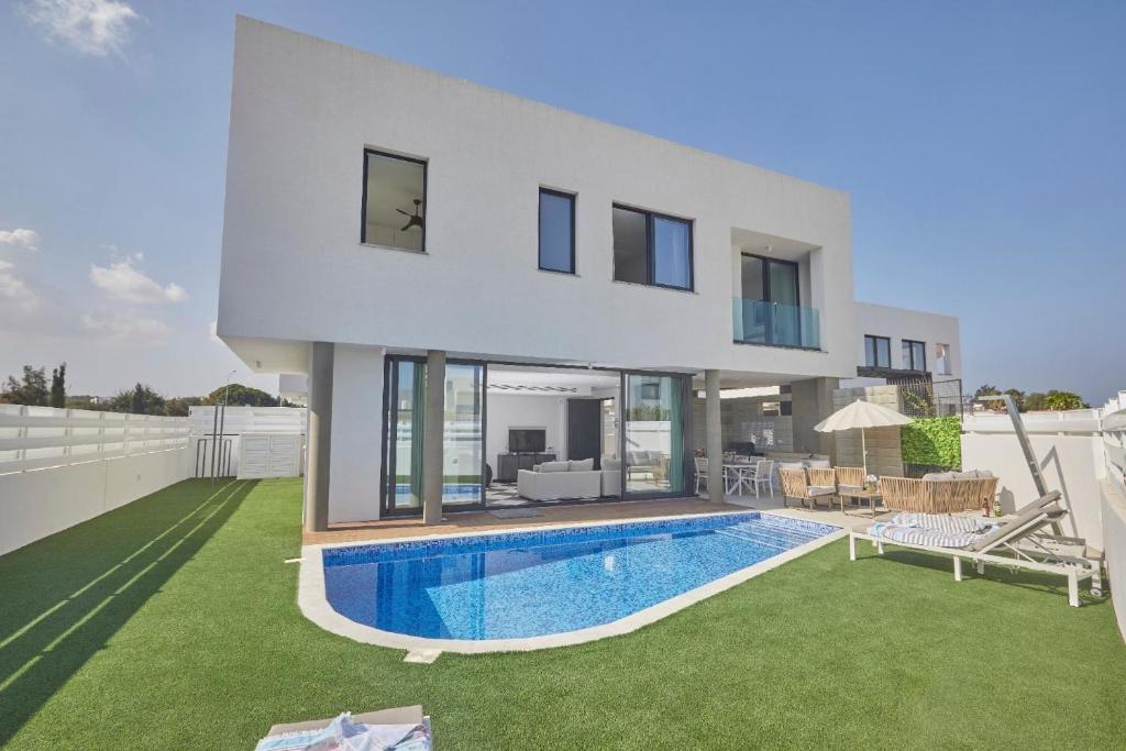 eine Villa mit einem Pool vor einem Haus in der Unterkunft Ferienhaus mit Privatpool für 6 Personen ca 135 m in Pernera, Südküste von Zypern in Protaras