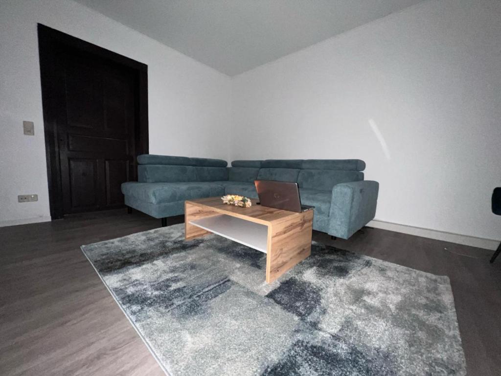 a living room with a blue couch and a coffee table at Gera Apartment EG in Gera