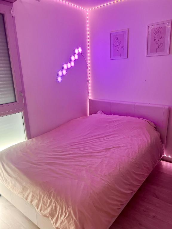 - une chambre dotée d'un lit avec des lumières violettes dans l'établissement Chambre à louer avec salle de bain privative, à Carrières-sous-Poissy
