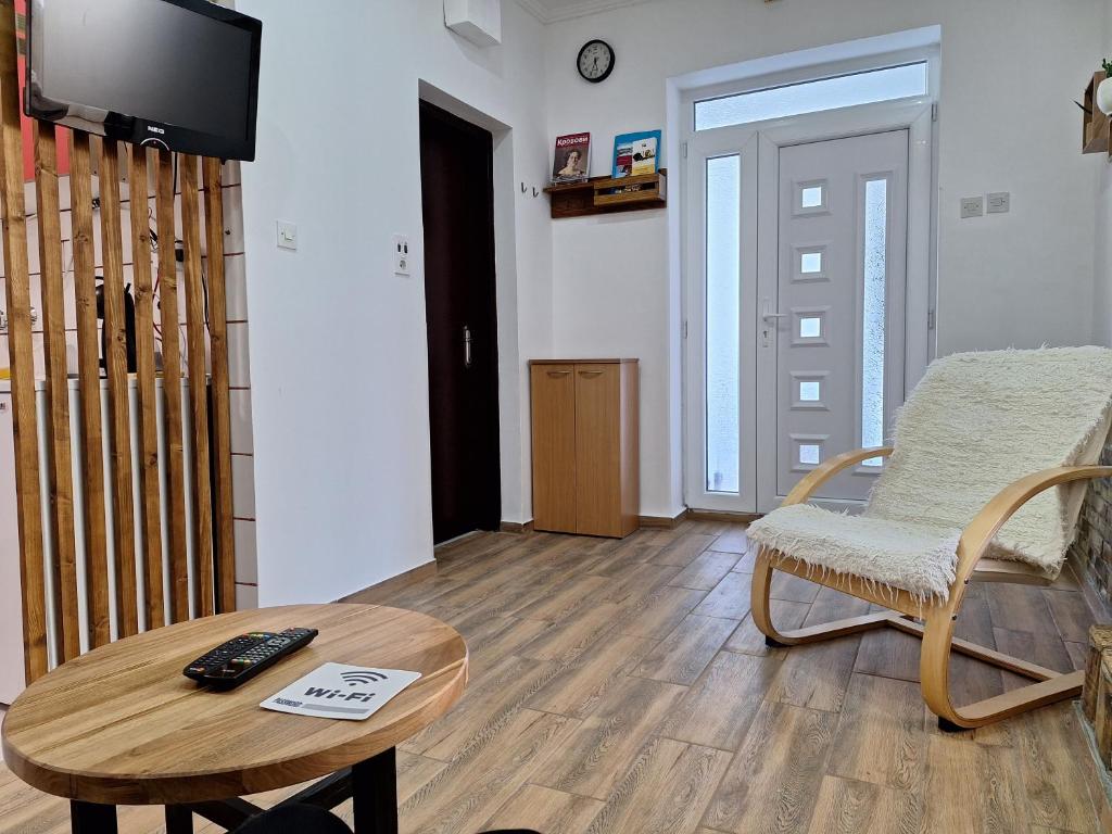 salon ze stołem, krzesłem i telewizorem w obiekcie Dora w mieście Sremski Karlovci