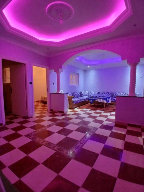 een kamer met een paars plafond en een geruite vloer bij Dar zahra in Aourir