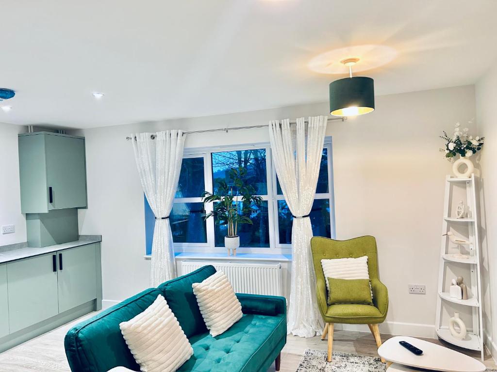 a living room with a blue couch and a window at Dover Castle Luxury Apartments in Kent