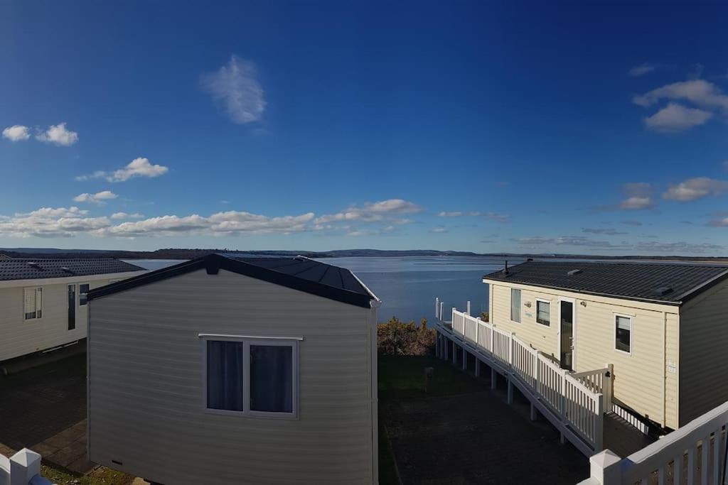 a row of houses with a view of the water at Cozy and relaxing with stunning sea views in Lytchett Minster