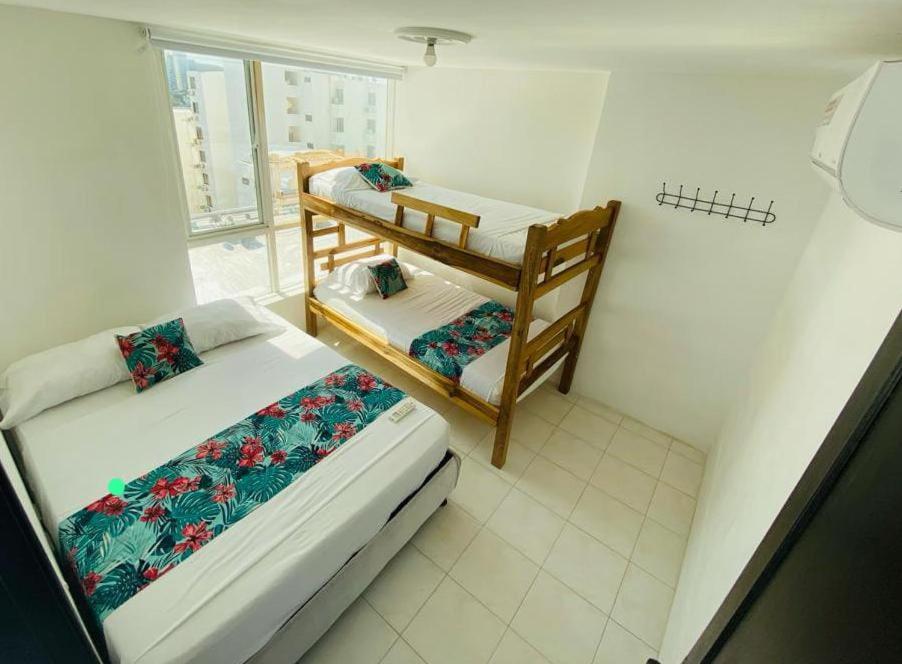 1 dormitorio con 2 literas y ventana en Apartamento Excalibur 11B junto al mar, en Gaira