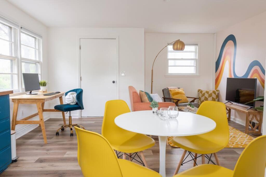 a living room with a table and yellow chairs at Retro Retreat: 1br home w/ WFH desk, livingroom, and fire pit in Kingston